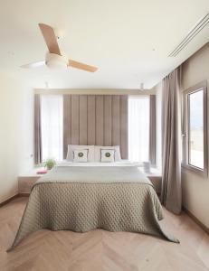 a bedroom with a large bed with a ceiling fan at Trabuxu Boutique Living in Valletta