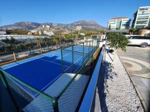 two tennis courts on top of a building at A dreamy luxury one-bedroom apartment with special views of the forest, sea and sunset in Alanya