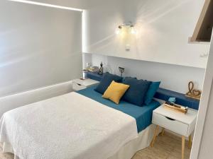 a small bedroom with a bed with blue pillows at New! Seaview-Vistas al Mar con Piscina en La Pineda in La Pineda