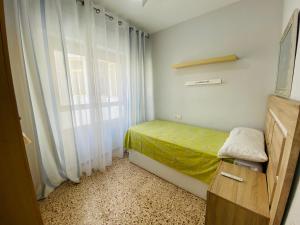 ein kleines Schlafzimmer mit einem Bett und einem Fenster in der Unterkunft Casa Don Juan in Santa Pola