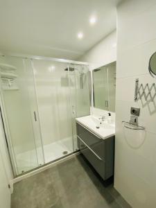 ein weißes Bad mit einer Dusche und einem Waschbecken in der Unterkunft Casa Don Juan in Santa Pola