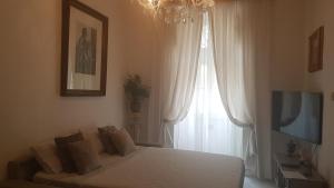 - une chambre avec un lit, une télévision et une fenêtre dans l'établissement St Gabriel's, à Tarxien