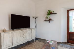 TV de pantalla plana en la parte superior de un centro de entretenimiento de madera en Dolce far niente, en San Romano