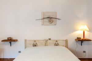 1 dormitorio con cama, lámpara y reloj en Dolce far niente, en San Romano