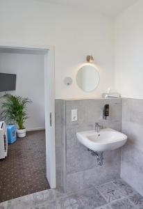 W łazience znajduje się umywalka i lustro. w obiekcie Pension Alte Molkerei w mieście Görlitz