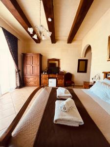 1 dormitorio con 2 toallas en una cama en Narcisa Farmhouse B&B, en Nadur