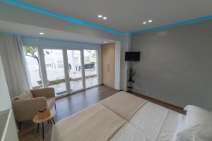 阿齊亞佩拉加的住宿－"BlueVedere" Sea View Luxury Villa，一间卧室配有一张床、一张沙发和一台电视。