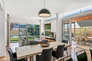 a dining room and living room with a table and chairs at Mosman Park Luxury Family Home with Pool & Alfresco Dining in Fremantle
