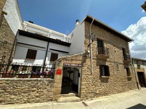 - un vieux bâtiment en pierre avec un balcon dans une rue dans l'établissement Casa Janices, à Artajona