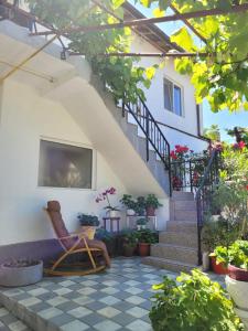 a patio with a chair and stairs with potted plants at Vila Didi, Mangalia in Mangalia