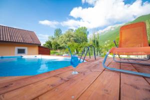 eine Terrasse mit einem Getränk und einem Stuhl neben einem Pool in der Unterkunft Villa Bezho Ljubanista in Ljubaništa