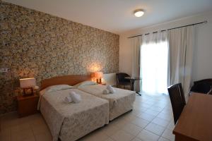 1 dormitorio con 1 cama y 2 toallas blancas en Palates Hotel, en Droushia