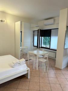 ミラノにあるEasy Milano Apartment Navigliのテーブル2台と椅子、窓が備わる客室です。
