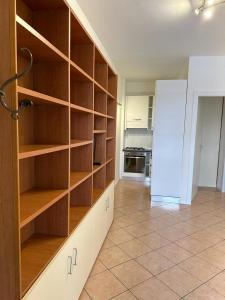 a room with wooden shelves in a kitchen with a refrigerator at Easy Milano Apartment Navigli in Milan