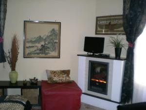 salon z telewizorem i kominkiem w obiekcie Orizzonte B&B w Cefalù