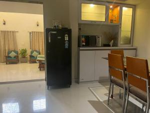 a black refrigerator in a room with a kitchen at Myra's house in Kolhapur