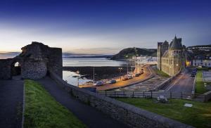 a view of a city with a castle and the ocean at Aberceiro Bungalow in Aberystwyth