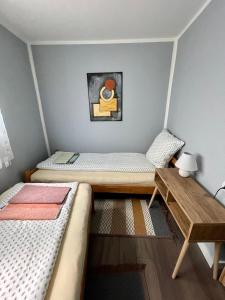 a room with two beds and a wooden table at Golden BIS 2, Subotica in Subotica