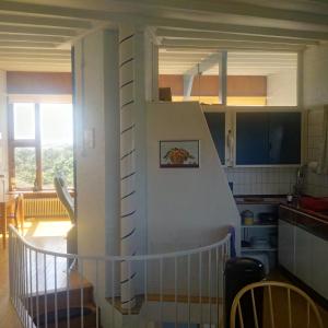 a kitchen with a staircase leading up to a kitchen with at Sachs Hoyz in Bergen aan Zee