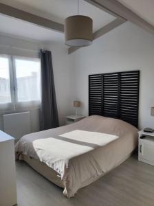 Un dormitorio con una cama grande y una ventana en Location saisonnière à St Hilaire de Riez, en Saint-Hilaire-de-Riez