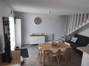 ein Wohnzimmer mit einem Tisch, Stühlen und einem Sofa in der Unterkunft Location saisonnière à St Hilaire de Riez in Saint-Hilaire-de-Riez