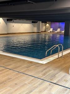 a large swimming pool with chairs in a building at Vadi İstanbul daire full eşya in Istanbul