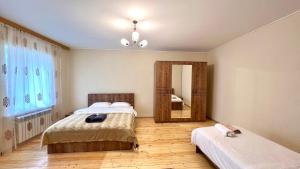 1 dormitorio con 2 camas y espejo en Secret Garden Guest House en Gabala