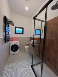 a bathroom with a washing machine and a washer and dryer at Mountain View Apartment in Mieres