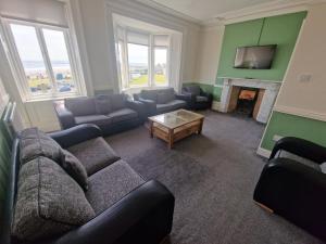 een woonkamer met een bank en een open haard bij 2 The Green, exceptional large house, sea views loads of bathrooms in Seaton Carew