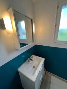La salle de bains est pourvue d'un lavabo blanc et d'un miroir. dans l'établissement Jour meilleur à Métabief, à Métabief