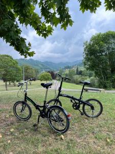 dos motos estacionadas en el césped en un campo en Mountain View Apartment, en Mieres