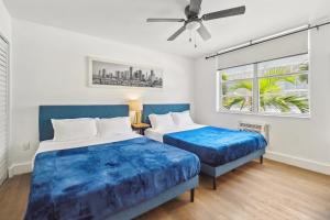Un dormitorio con dos camas y un ventilador de techo. en 713 Miami Beach Apartments, en Miami Beach