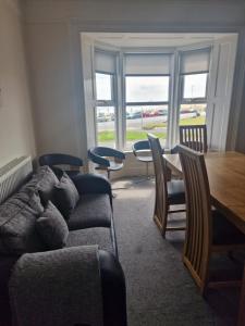 een woonkamer met een bank en een tafel en stoelen bij 2 The Green, exceptional large house, sea views loads of bathrooms in Seaton Carew
