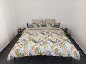 a bedroom with a bed with a floral bedspread at O'Couvent - Appartement 62 m2 - 2 chambres - A513 in Salins-les-Bains
