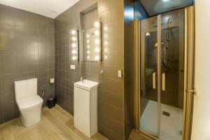 un baño con inodoro y ducha en APARTAMENTOS MAPAMUNDI, en Badajoz 35 fotos más
