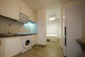 Una cocina con lavadora y secadora en una habitación. en APARTAMENTOS MAPAMUNDI, en Badajoz