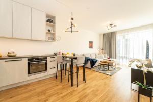 a kitchen and living room with a table and chairs at Citygate Sunset balcony in Tartu