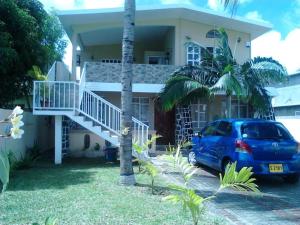 a blue car parked in front of a house at Jolie Villa Santa avec piscine in Pointe aux Piments