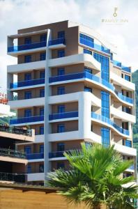a tall building with a palm tree in front of it at Family Inn in Gonio
