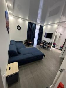 a bedroom with a blue bed and a living room at Family Inn in Gonio