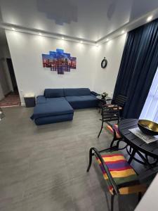 a living room with a blue couch and a table at Family Inn in Gonio