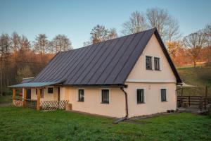 ein Haus mit schwarzem Dach in der Unterkunft Chalupa Babí 113 in Trutnov