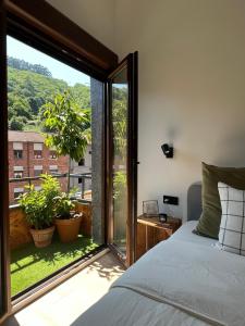 1 dormitorio con cama y ventana grande en Mountain View Apartment, en Mieres