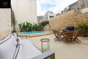 um pátio com uma mesa e cadeiras e uma piscina em Ultimate Luxury Home experience in Beautiful Rabat by 360 Estates em Rabat