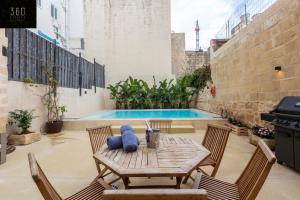 eine Terrasse mit einem Tisch, Stühlen und einem Pool in der Unterkunft Ultimate Luxury Home experience in Beautiful Rabat by 360 Estates in Rabat