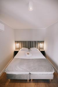 sypialnia z dużym łóżkiem z białą pościelą w obiekcie Między Murami w Toruniu