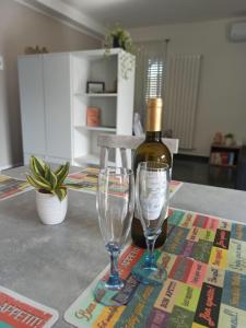Una botella de vino y dos copas en una mesa. en Il Glicine appartamento vacanze, non solo mare!, en Casarza Ligure
