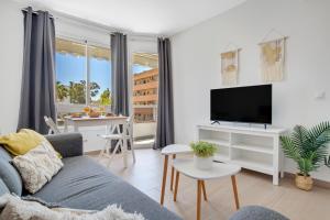 a living room with a couch and a tv at Vistamarina B201 By IVI Real Estate in Torremolinos