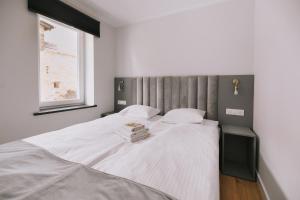 - une chambre avec un grand lit blanc et une fenêtre dans l'établissement Między Murami, à Toruń