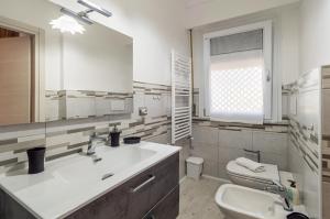 La salle de bains est pourvue d'un lavabo, de toilettes et d'un miroir. dans l'établissement Domus Lucis Apartment Terrace & Private Parking, à Marinella di Sarzana